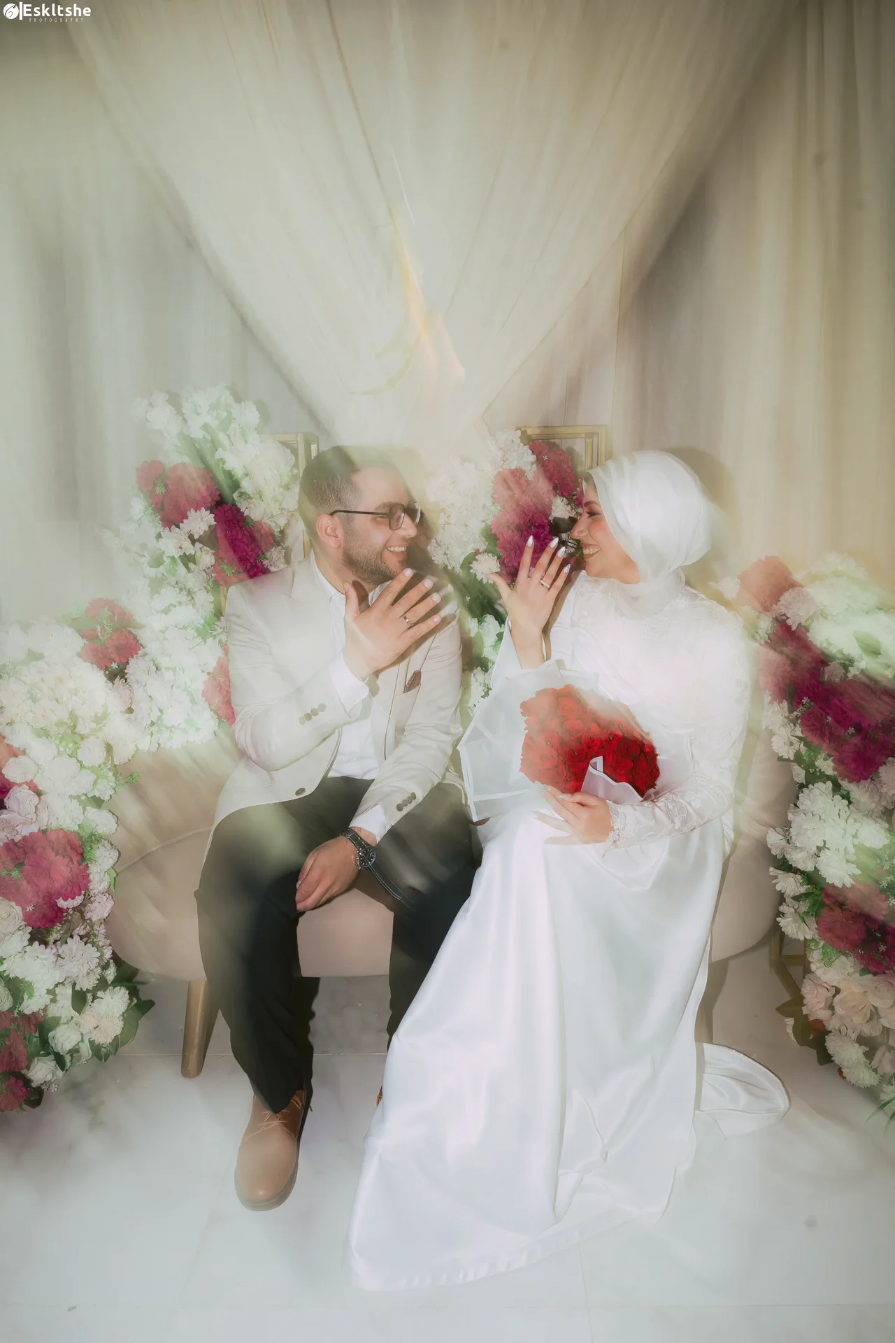 Ahmed and Rawan showing their rings beneath soft light